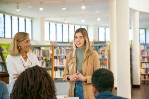woman confidently speaking to people in a library, how to sell a daycare