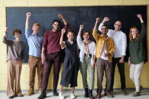 community of smiling teachers raising their fists in the air